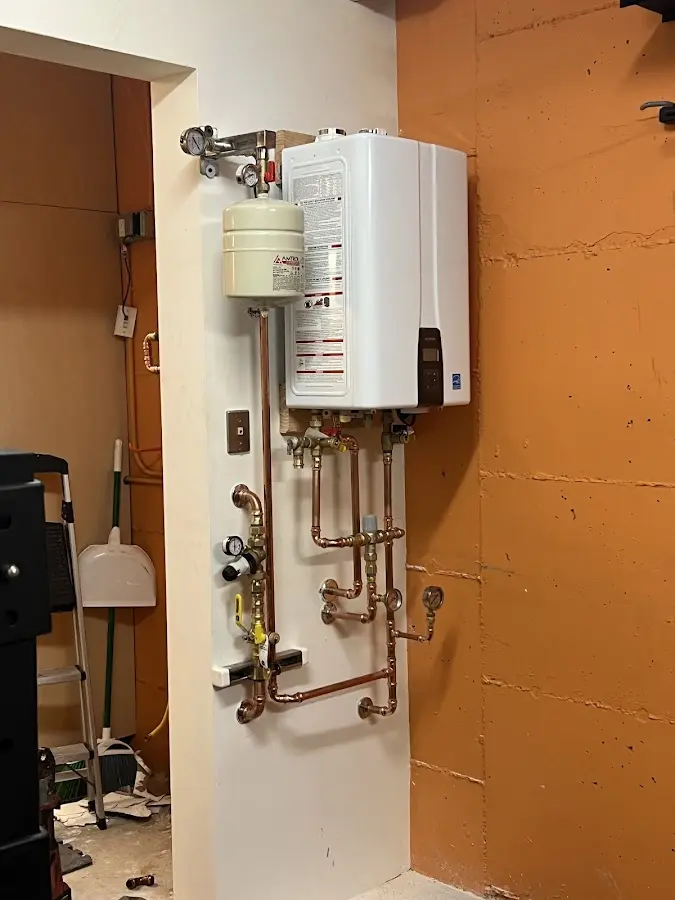 Plumbing technician inspecting water heater connections in Adairsville